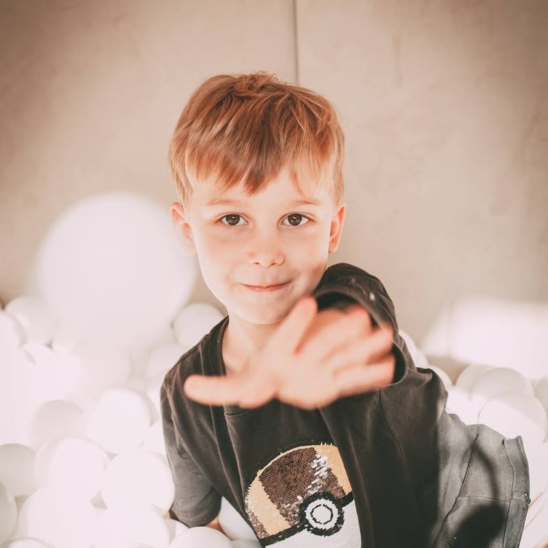 Vlad playing in a ball pit, reaching toward the camera
